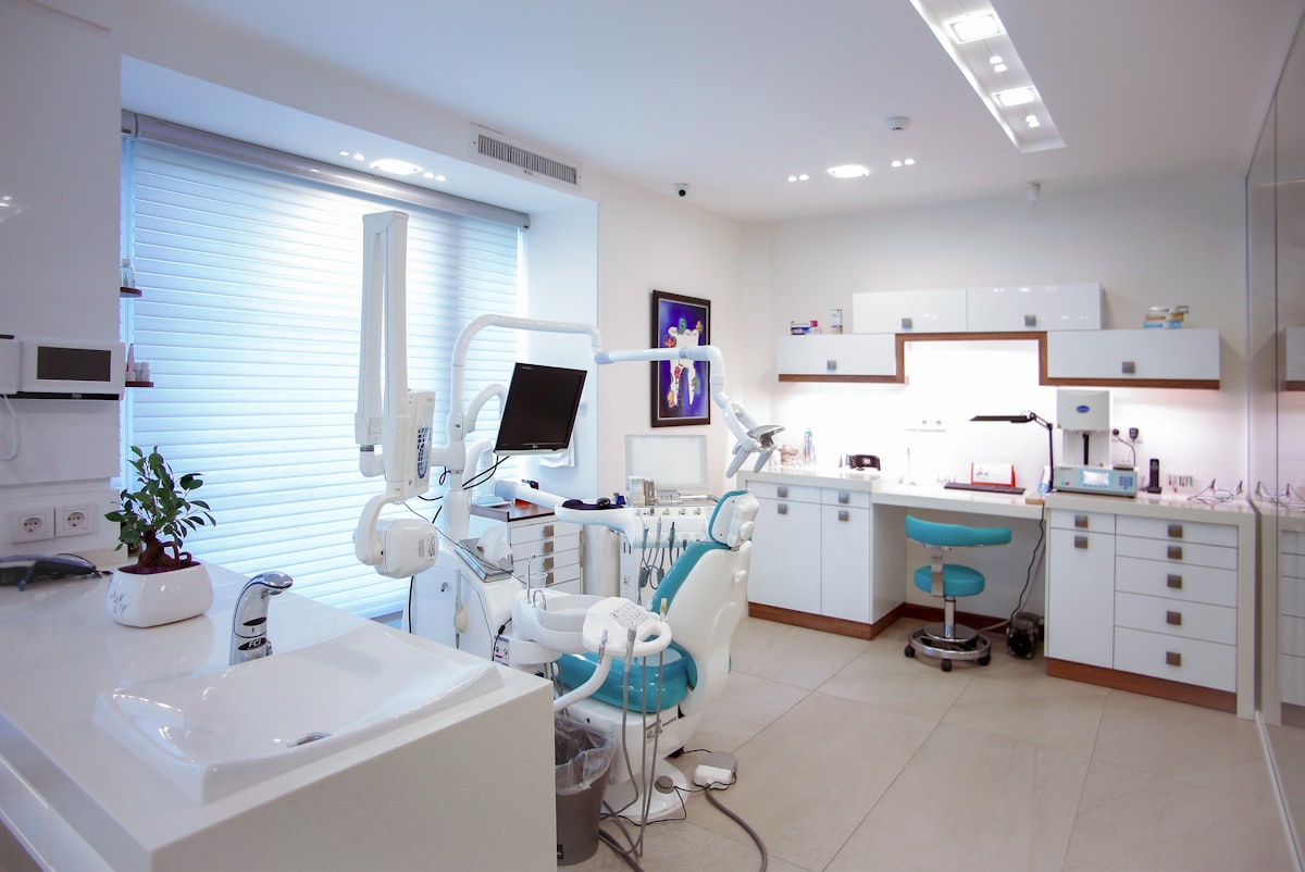 Bright treatment room with a teal dental chair at Northline Dental