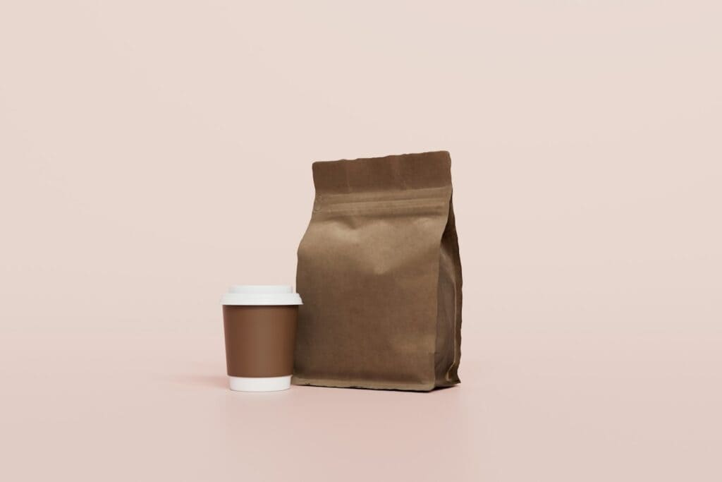 A coffee bag beside a takeaway cup