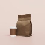 A coffee bag beside a takeaway cup