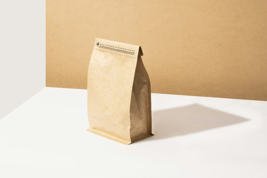 A kraft coffee bag standing on a tan background