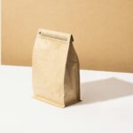 A kraft coffee bag standing on a tan background