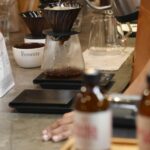 A row of pour-over drippers on a brew bar