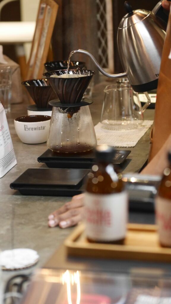 A row of pour-over drippers on a brew bar