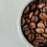 Roasted coffee beans in a white ceramic bowl