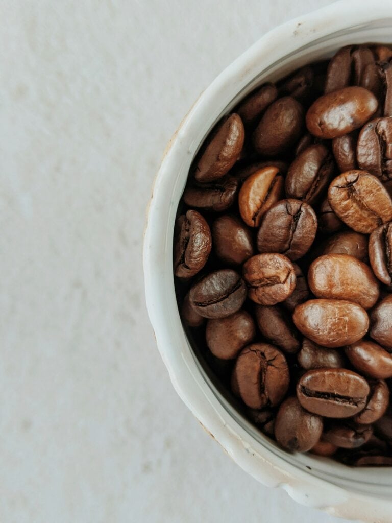Roasted coffee beans in a white ceramic bowl