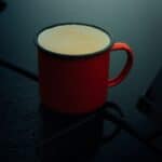 A red enamel mug against a dark background