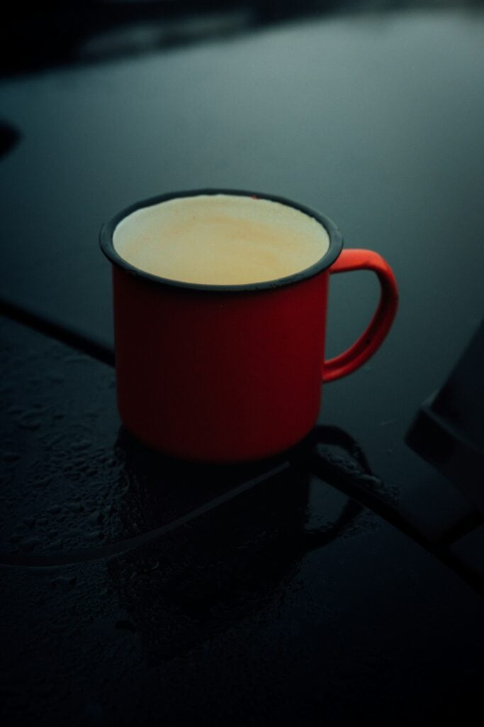 A red enamel mug against a dark background