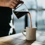 Filter coffee being poured into a ceramic mug