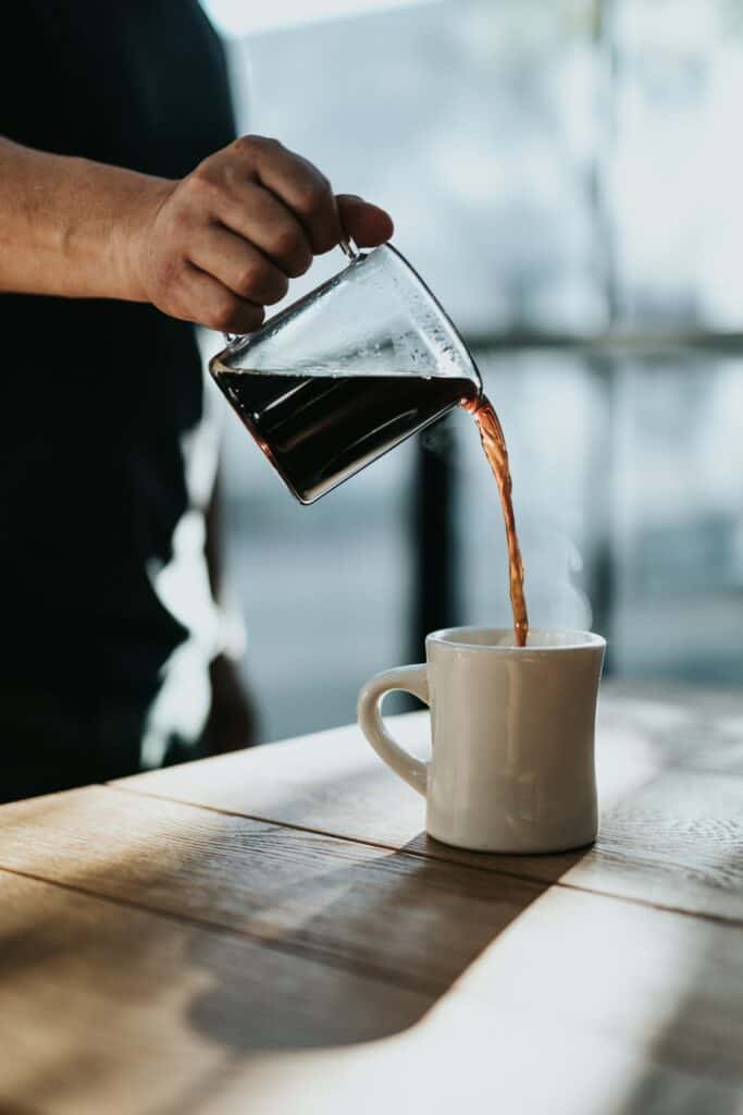 Filter coffee being poured into a ceramic mug