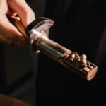 A hand holding a scoop of freshly roasted beans