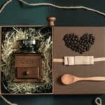 A gift box holding a hand grinder and loose beans